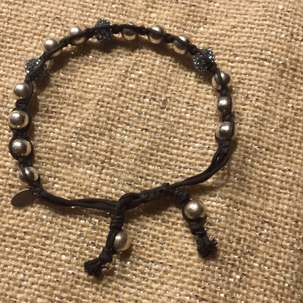 Sparkly blue and silver beads on brown bracelet.